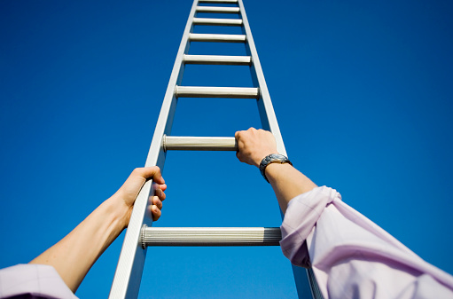 Personal perspective of a businessman climbing a ladder themes of success challenge beginnings