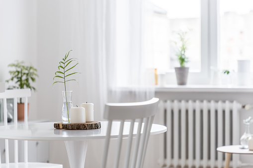 Cozy home interior with white, round table and wooden chairs