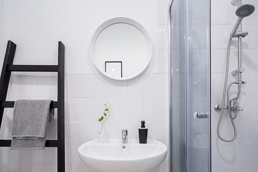 Scandinavian white bathroom with creative ladder shelf for towels