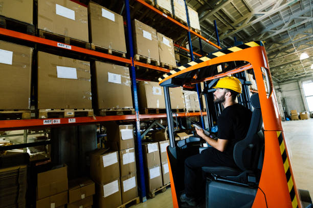 Warehouse worker doing logistics work with forklift loader Warehouse industry worker doing logistics work with forklift loader stacker stock pictures, royalty-free photos & images