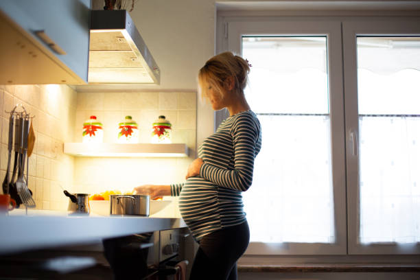 Pregnant Woman Cooking in Kitchen stock photo