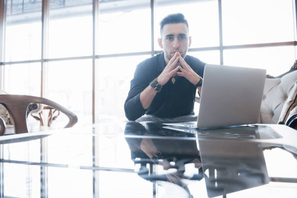 istock Conceived young man working on laptop while sitting at his working place in office 1137344516