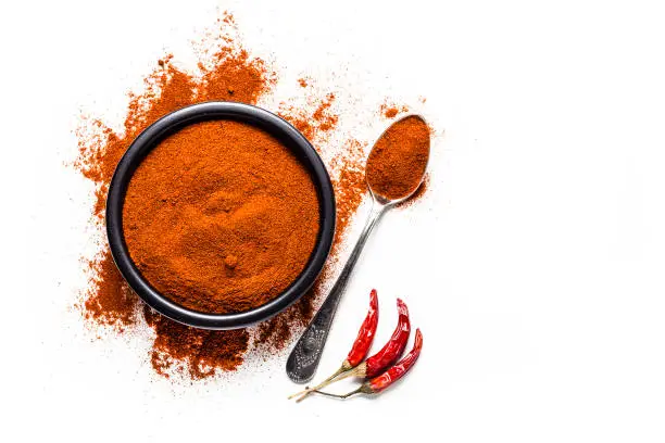 Photo of Spices: Red chili pepper powder shot from above on white background