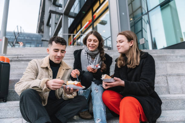 istock three young travellers having curry sausage outdoors in Berlin 1137346303
