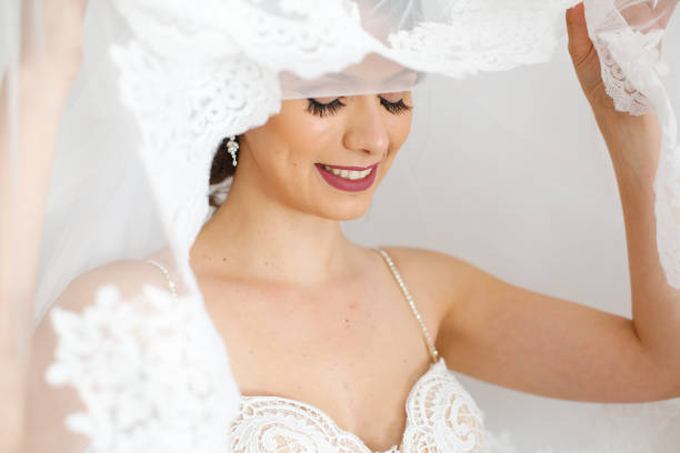 istock A brunette bride with a veil smiles at the camera 1137346459