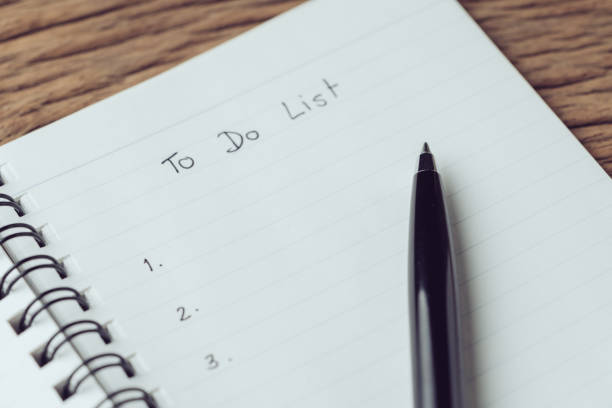 istock Black pen on what to do in personal to do list note pad on wooden table using as task list, things to complete and project check list 1137346537