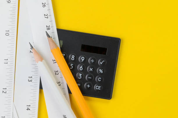 Calculator, pencils and white measuring tapes with centimetre and inches on vivid yellow background, length, long or maker instrument and enginerring tools concept Calculator, pencils and white measuring tapes with centimetre and inches on vivid yellow background, length, long or maker instrument and enginerring tools concept. centimetre stock pictures, royalty-free photos & images