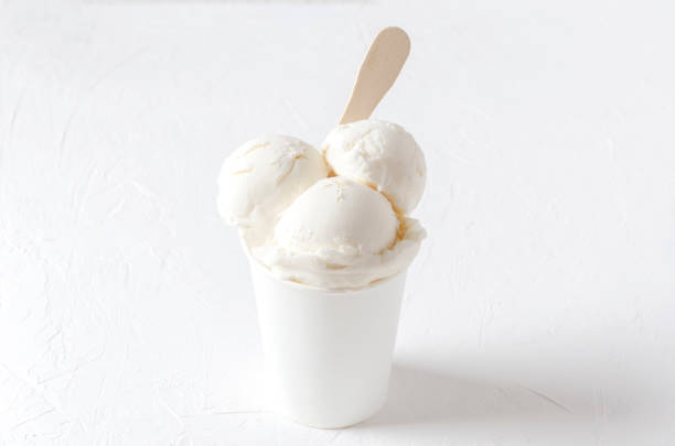 ホワイトバニラの美味しいアイスクリームを紙コップに。完全に白いショット。サマータイム製品 - vanilla ice cream ice ice cream organic ストックフォトと画像