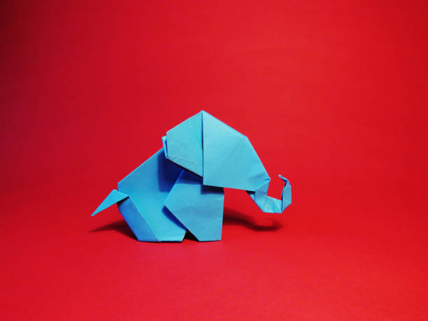 istock Origami blue elephant on a red background 1137347337