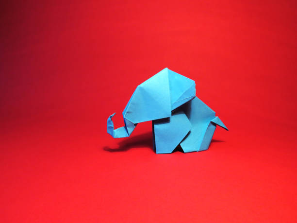 istock Origami blue elephant on a red background 1137347367