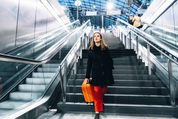 istock young woman coming down stairs in train station 1137347437