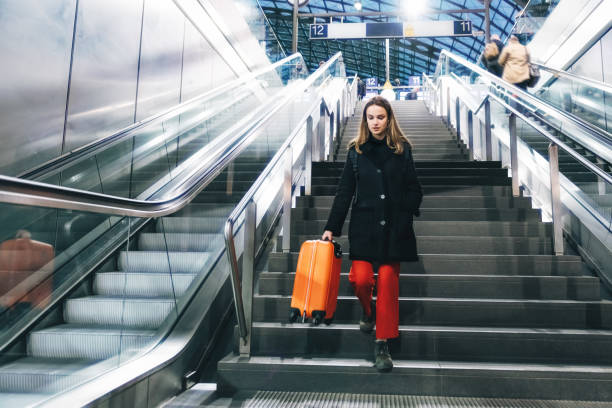 istock young woman coming down stairs in train station 1137347492