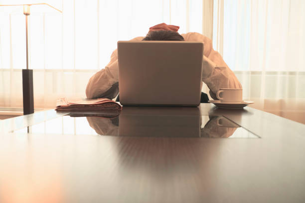 Caucasian businessman hiding behind laptop