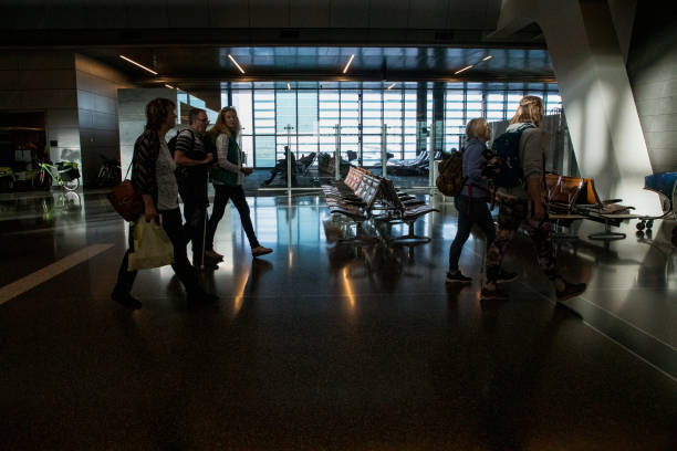 Walking Through Airport A side-view shot of a group of tourists walking together through an airport in India, they are carrying luggage with them, some members of the group are visually impaired and can be seen using walking canes to guide them. india airport stock pictures, royalty-free photos & images
