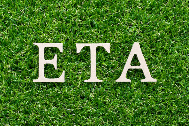 istock Wood alphabet in word ETA (abbreviation of Estimated Time of Arrival) on artificial green grass background 1137352023