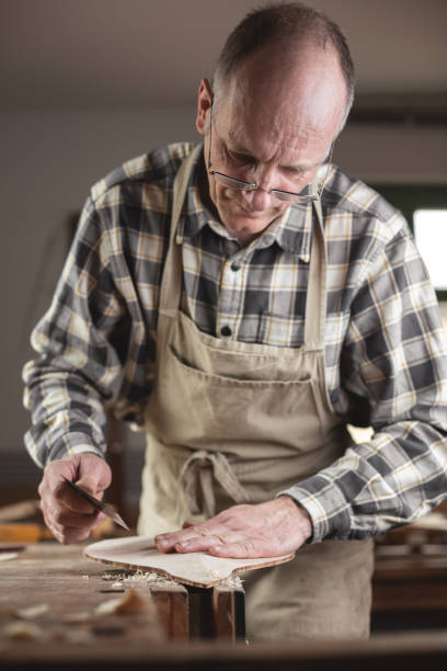 istock Experienced instrument maker examining a piece of wood 1137352714