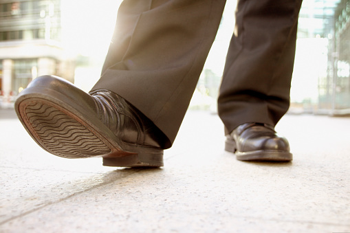 Low angle of a businessman shoes themes of best foot forward walking unrecognisable person