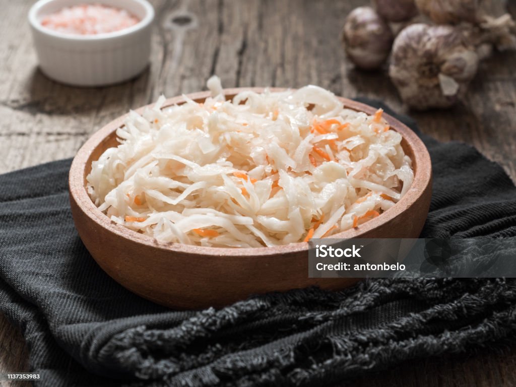 Sauerkraut. Fermented cabbage in a brown clay plate on a wooden table. Healthy vegetarian food and best natural probiotic Appetizer Stock Photo