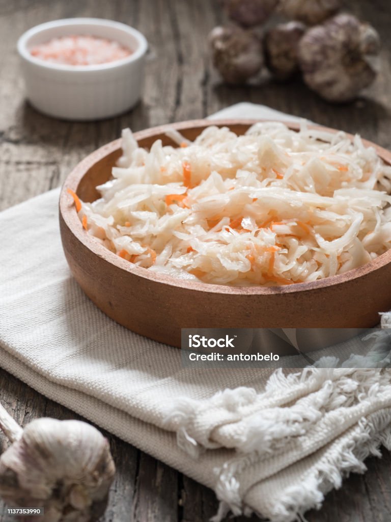 Sauerkraut. Fermented cabbage in a brown clay plate on a wooden table. Healthy vegetarian food and best natural probiotic Appetizer Stock Photo