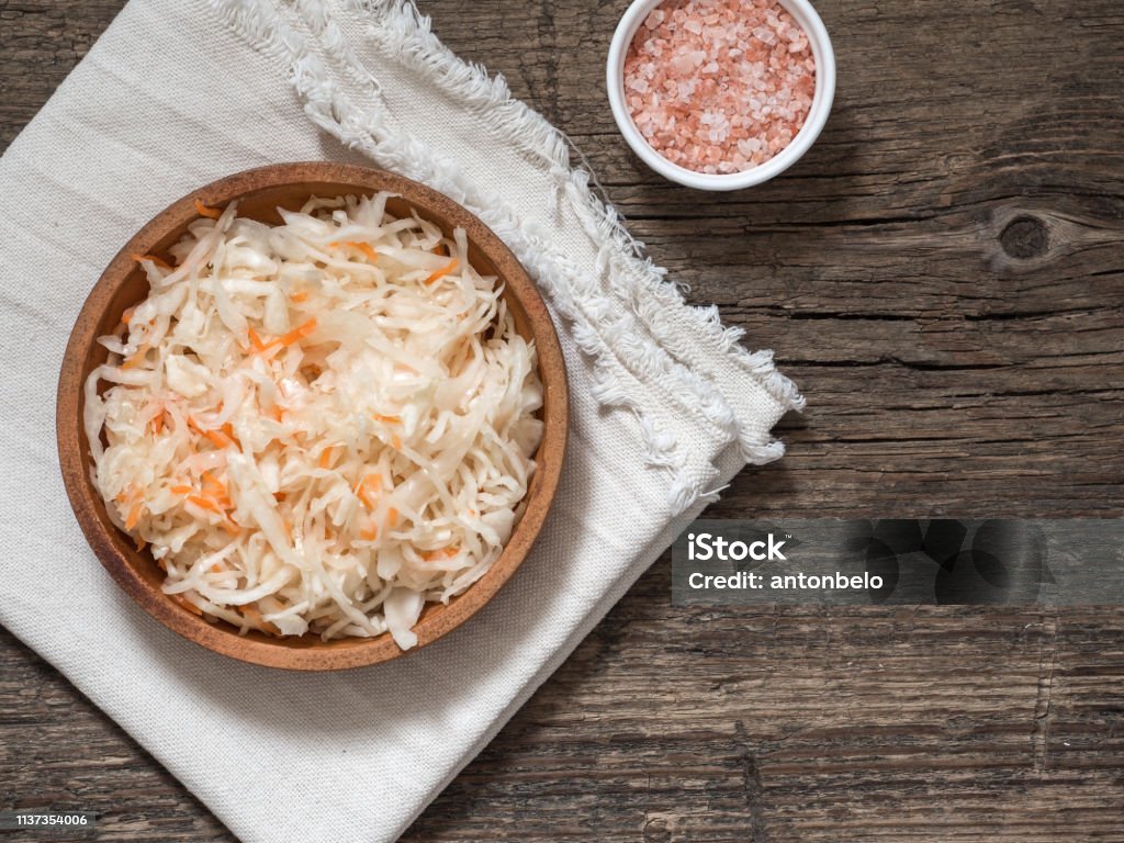 Sauerkraut. Fermented cabbage in a brown clay plate on a wooden table. Healthy vegetarian food and best natural probiotic Appetizer Stock Photo