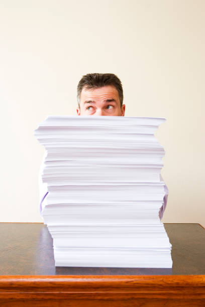 istock Caucasian businessman behind a stack of paper 1137355168