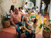 Happy mexican grandparents and grandson playing with balloon
