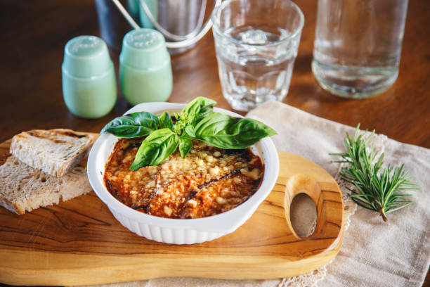 Eggplant casserole with parmesan cheese crust, served with fresh basil and bread