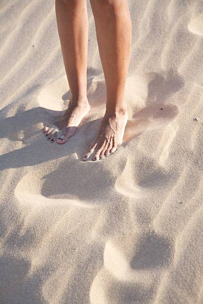 istock woman legs on sand beach 113736143