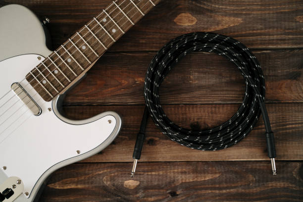 istock Guitar electric rock background. Cable jack on wooden table, top view 1137361645