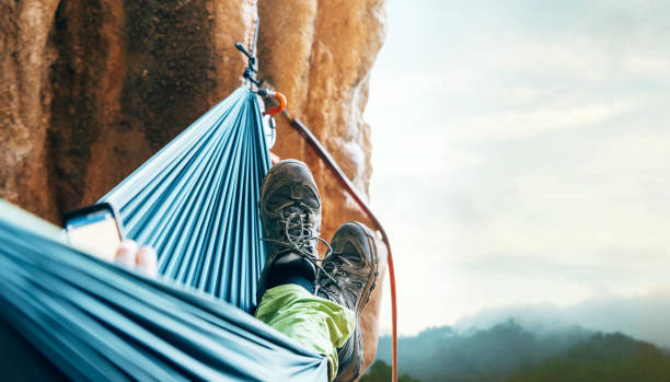 wspinacz odpoczywa w hamomoku na ścianie klifu - mountain mountain climbing climbing snow zdjęcia i obrazy z banku zdjęć