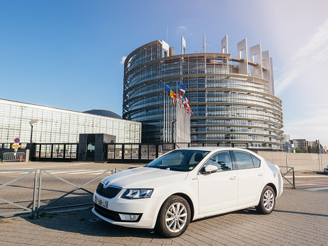 Strasbourg, France - Sep 3, 2017: New Skoda Octavia white limousine car parked front of European Parliament in Strasbourg on a clear sunny day