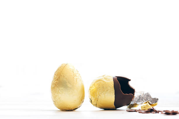 istock Stylish Easter egg in golden foil and broken chocolate egg with chocolate pieces in white light with space for text. Modern chocolate gold easter eggs. Happy Easter. Holiday gift. 1137367650