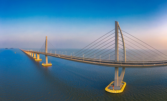 An aerial view of Hong Kong-Zhuhai-Macao Bridge in Zhuhai, Guangdong Province of China. The Hong Kong–Zhuhai–Macau Bridge is a bridge–tunnel system, which consists of a series of three cable-stayed bridges and one undersea tunnel, as well as two artificial islands. The bridge was opened on 23 October 2018.