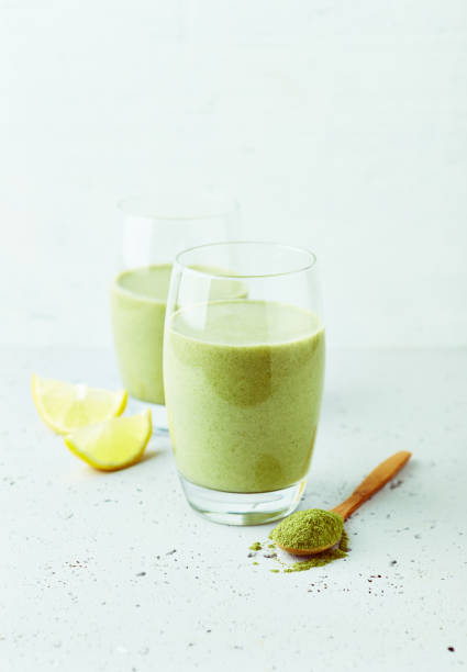 avocado-bananen-smoothie aus mandelmilch und jungem gerstengras. platz kopieren. gesunde ernährung. natürliche nahrung - barley grass juice green stock-fotos und bilder