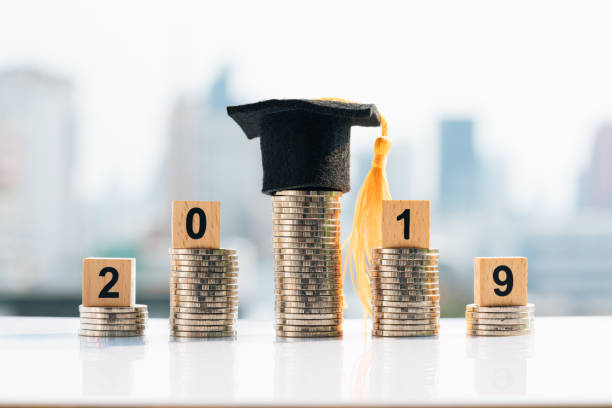 istock Graduation hat on top coin stack with 2019 wooden blocks. 1137372007