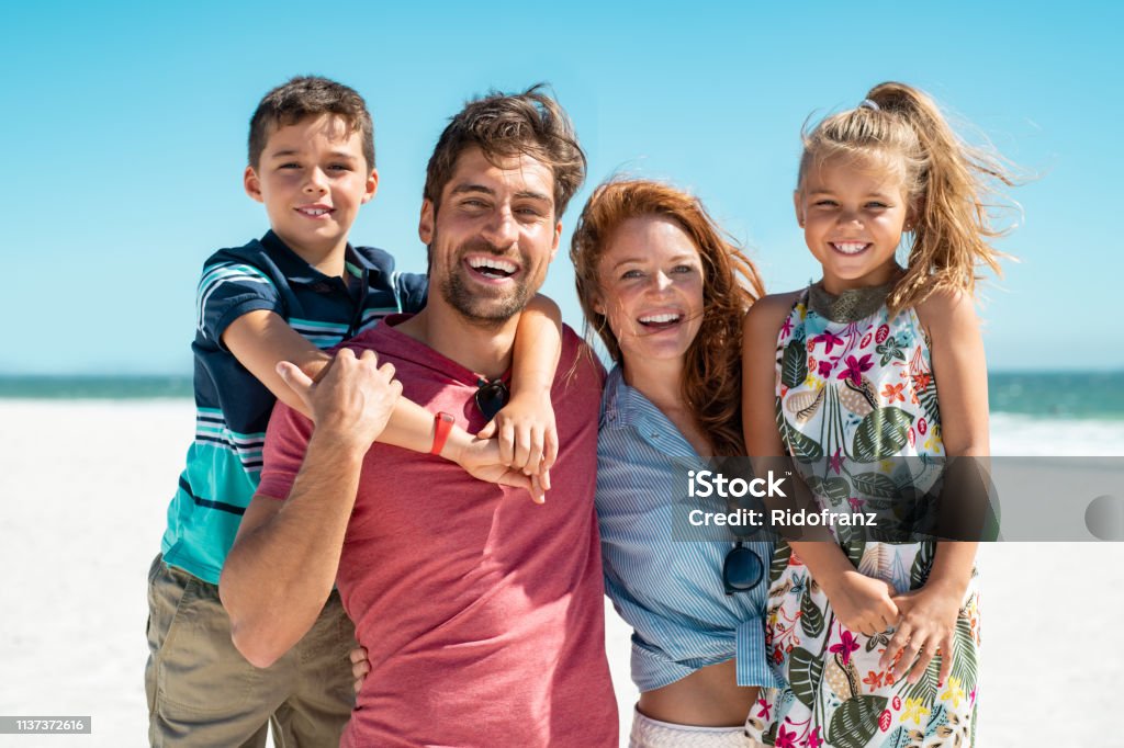 Famiglia felice sorridente in spiaggia - Foto stock royalty-free di Famiglia