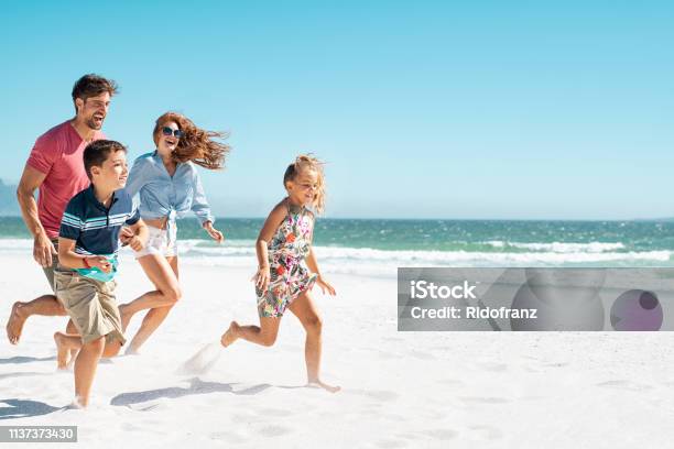 Happy Family Running On Beach Stock Photo - Download Image Now - Family, Beach, Vacations