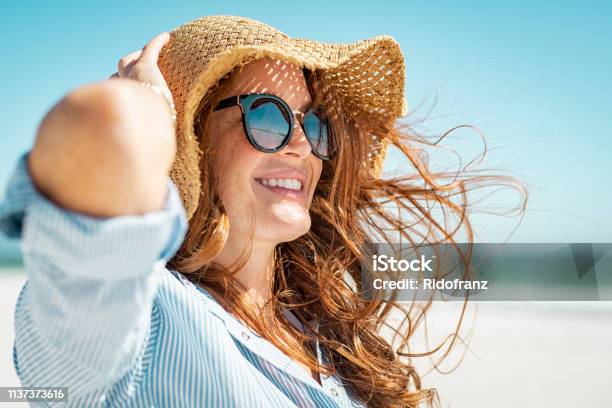 Photo libre de droit de Femme Mature Avec Le Chapeau Et Les Lunettes De Soleil De Plage banque d'images et plus d'images libres de droit de Femmes