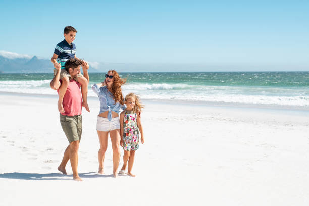 famiglia a piedi in spiaggia - family with two children father clothing smiling foto e immagini stock