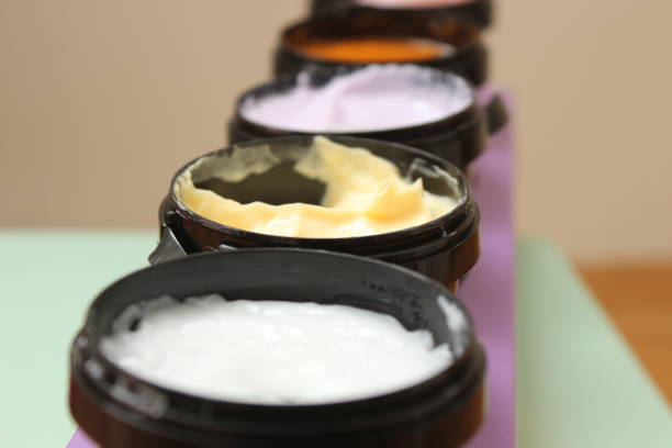 Various angle and view on five plastic containers with colorful organic natural creams for body and face and feet