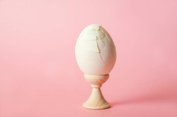 istock A cracked egg on a pink background close-up and copy space. One egg, easter concept, smash 1137380504