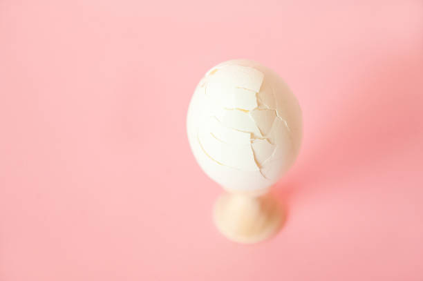 istock A cracked egg on a pink background close-up and copy space. One egg, easter concept, smash 1137380506