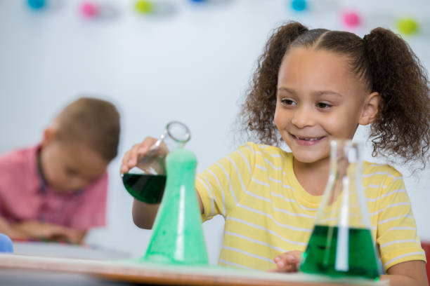 istock Adorable elementary age little girl doing chemistry experiment in STEM class 1137387038