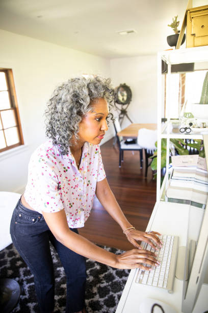 Woman Working at home with a standing desk A black woman working from home using a standing desk standing desk photos stock pictures, royalty-free photos & images