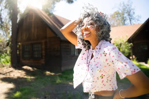 Photo of Carefree black woman with hand in her hair laughing