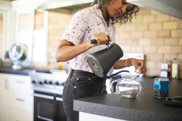 istock Black Woman Pouring Tea in Kitchen 1137388382