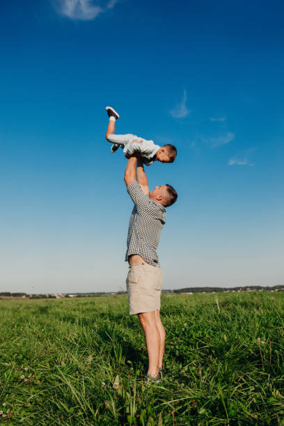 istock Happy man with child playing together in field 1137389716