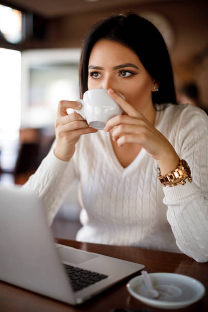 istock Young woman drinking coffee at the cafe 1137392473