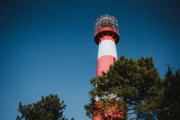 istock Red and white lighthouse on the background of a blue sky 1137397585