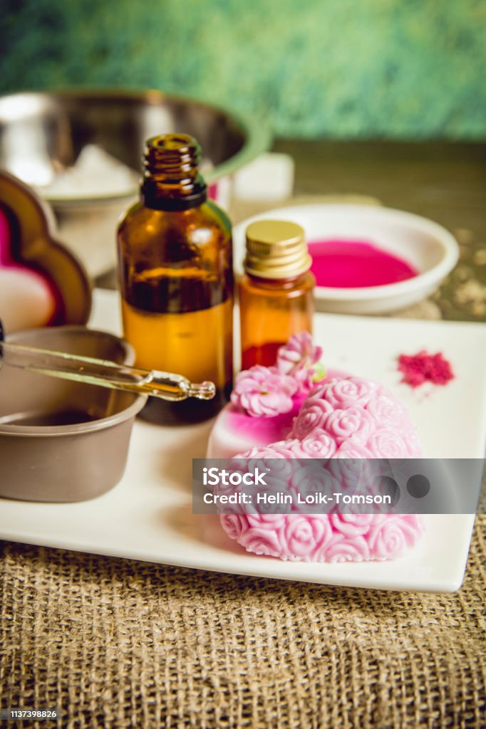 Making soap from pour and melt soap base concept. Soap making ingredients  on brown wooden background. melt and pour method, buy a soap base that's  already been made and cured. Stock Photo